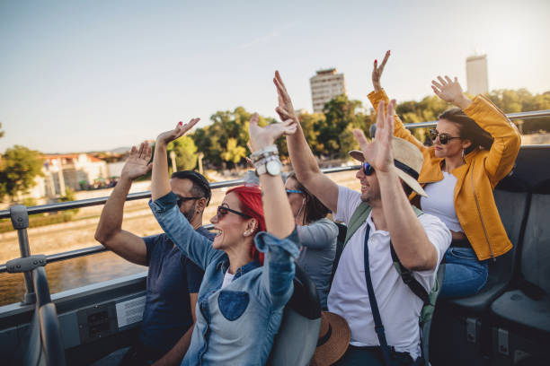 Tourists enjoying a ride on a open-air tour bus in autumn.